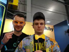 Two men posing with orange glasses and yellow bow tie