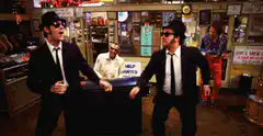 Two men in suits dancing in a shop