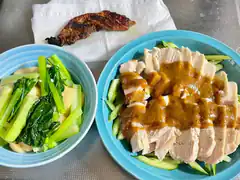Hainanese chicken rice with gravy and greens
