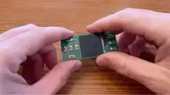 Hands holding a Seed Diner handheld console