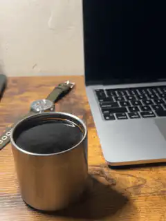 coffee cup on desk next to laptop