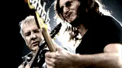Two men playing bass guitar on stage