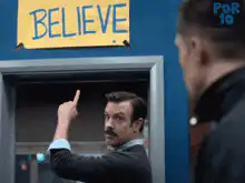 Ted Lasso points to BELIEVE sign