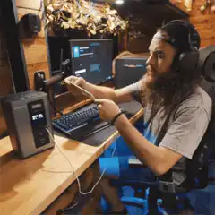 bearded man plugs phone into computer