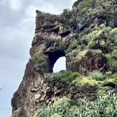 rocky cliff with natural arch and cacti