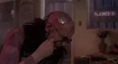 Bald man with glasses rubbing his head