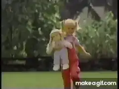 Blonde girl holding a doll outdoors