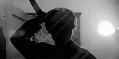 Silhouette holding a knife to head