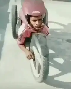Boy riding homemade cardboard motorcycle
