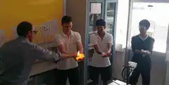 Students passing flaming hands in science class