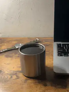 Coffee cup on desk next to laptop