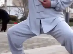 Man in white martial arts uniform practicing tai chi