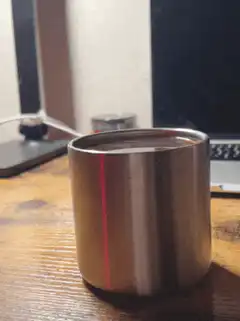 metal cup on wooden desk
