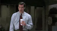 Jim Carrey holding a cup and smiling