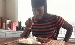 Man eating with two guns