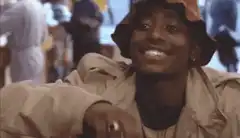 Tupac smiling and making a peace sign
