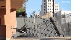Skateboarder grinding rail on stairs