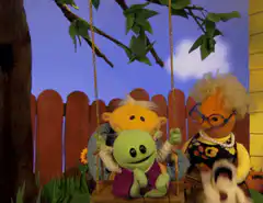 green puppet swings on a swing