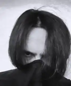 person with long hair covering face