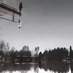 person jumping off dock into lake