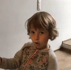 Child making surprised face and waving