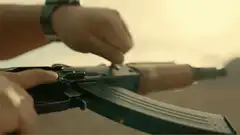 Hand cocking an AK-47 rifle