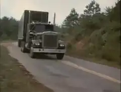 Semi truck driving on dirt road