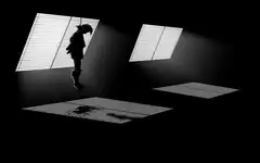 Silhouette of a hanging person in a dark room