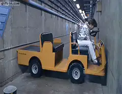 Man in silver suit driving golf cart in tunnel