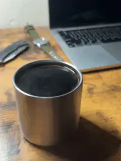 Steaming metal cup on desk