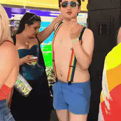 Shirtless man with rainbow suspenders dancing