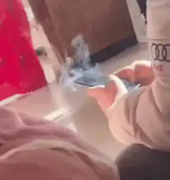 Person holding smoking smartphone