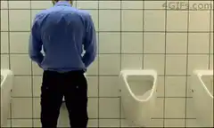 man standing at urinal in huge bathroom