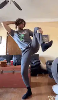 Man stretching leg high in living room