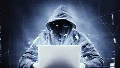 Hacker typing on laptop with digital effects