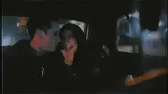 Couple kissing in car at night