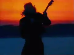 Silhouette playing guitar at sunset