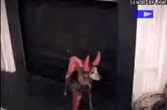 Dog in devil costume by fireplace