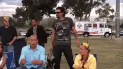 Man kicks chair and sits down