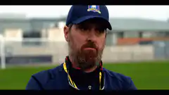 Bearded man in blue cap looking down