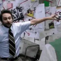 Charlie Day pointing at wall