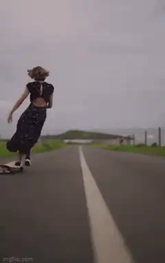 woman skateboarding down road