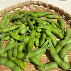 Green edamame beans in a bamboo basket