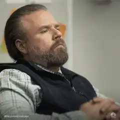 Man in vest thinking and touching nose
