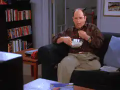 George Costanza eating cereal on the couch