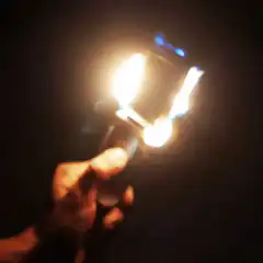Hand holding a burning flip phone