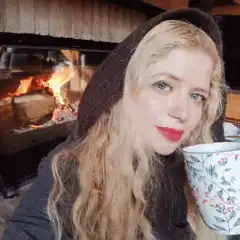 woman drinking tea by fireplace