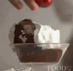 Hand placing cherry on dessert