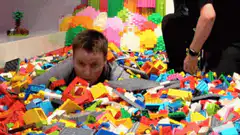 man buried in lego bricks