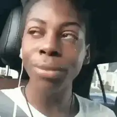 Woman crying in car wipes tears